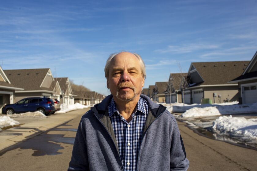 Jeffrey Carlson stands for a portrait outside his home in Vadnais Heights, Minn., on Sunday, March 13, 2022. Carlson, a Type 1 diabetic with heart stents, contracted COVID-19 in January, but recovered quickly after being treated with Merck's molnupiravir medication. (AP Photo/Nicole Neri)