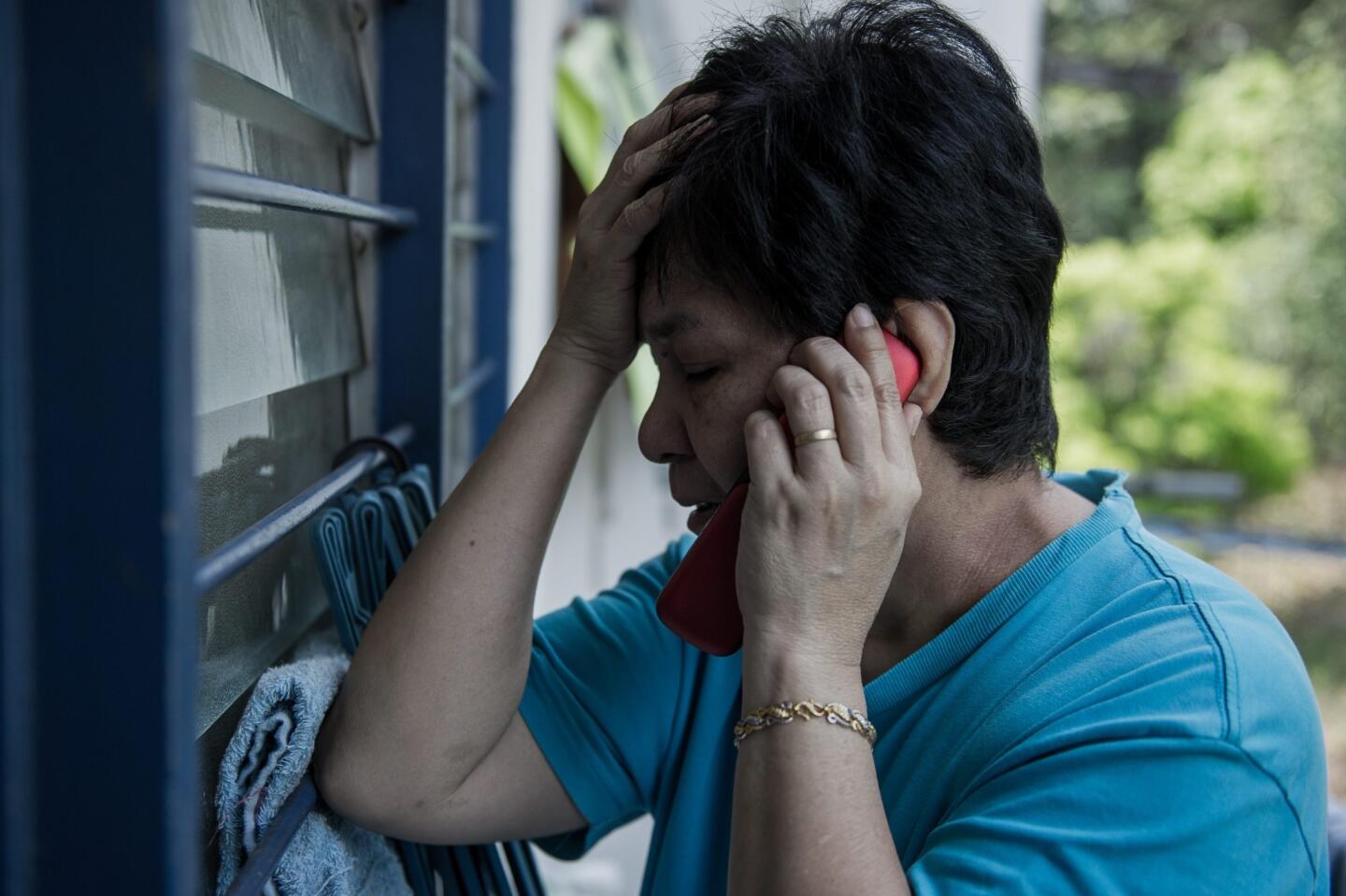 Sarah Nor, 55, the mother of 34-year-old Norliakmar Hamid, a passenger on a missing Malaysia Airlines Boeing 777-200 plane, talks on a mobile phone at her house in Kuala Lumpur.