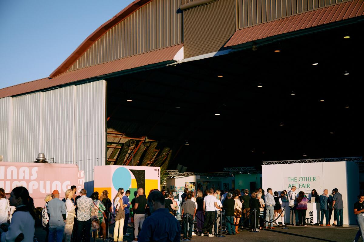 People lined up outside a hangar. 