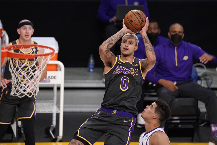 Los Angeles Lakers forward Kyle Kuzma, center, shoots as Denver Nuggets forward Michael Porter Jr., right, defends and guard Alex Caruso watches during the first half of an NBA basketball game Monday, May 3, 2021, in Los Angeles. (AP Photo/Mark J. Terrill)