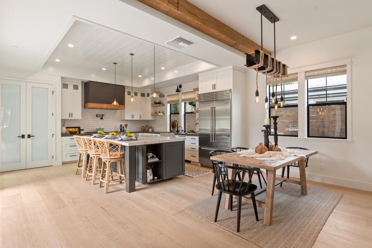A kitchen in a newly designed home has engineered hardwood floors in a light tone.
