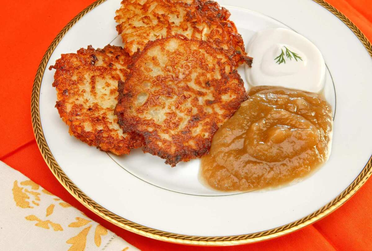 Apple sauce made from stewed apples in a pressure cooker, alongside latkes.
