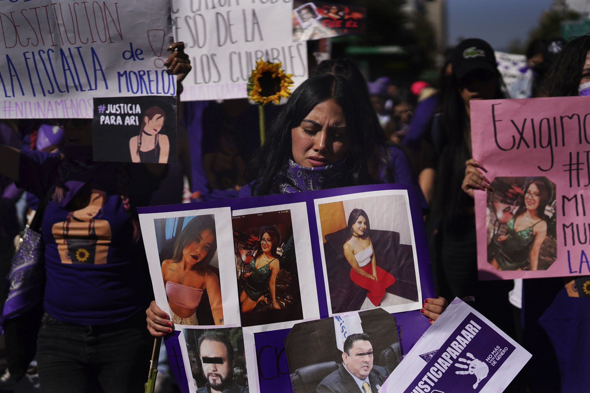 Protesters hold signs and photos of Ariadna López, whose body was found dumped beside a highway.