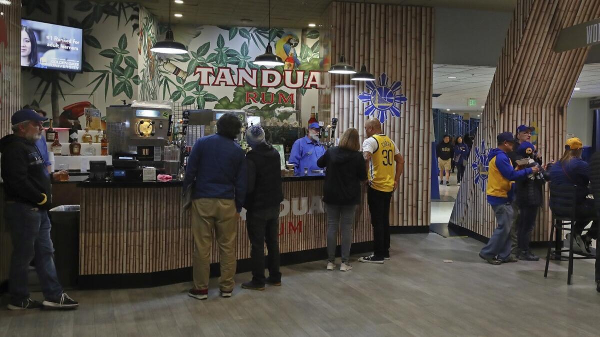Fans order drinks in an exclusive bar area in Oracle Arena before a Golden State Warriors game.