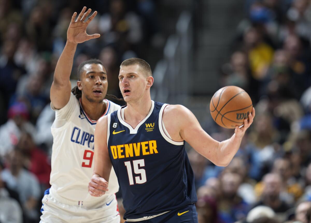 Nuggets center Nikola Jokic looks to pass the ball as Clippers center Moses Brown defends Jan. 5, 2023.