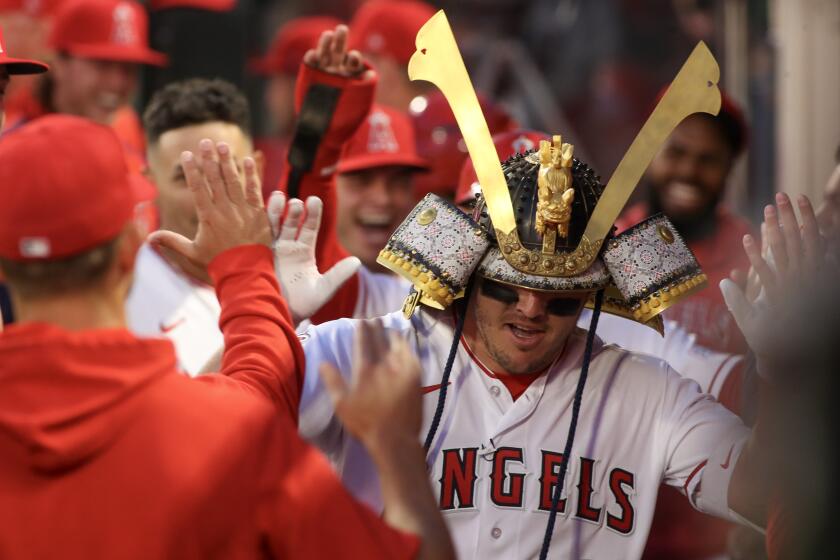 ANAHEIM, CA - APRIL 07: Mike Trout gets high fives in the dugout after blasting a two-run homer on his first pitch.
