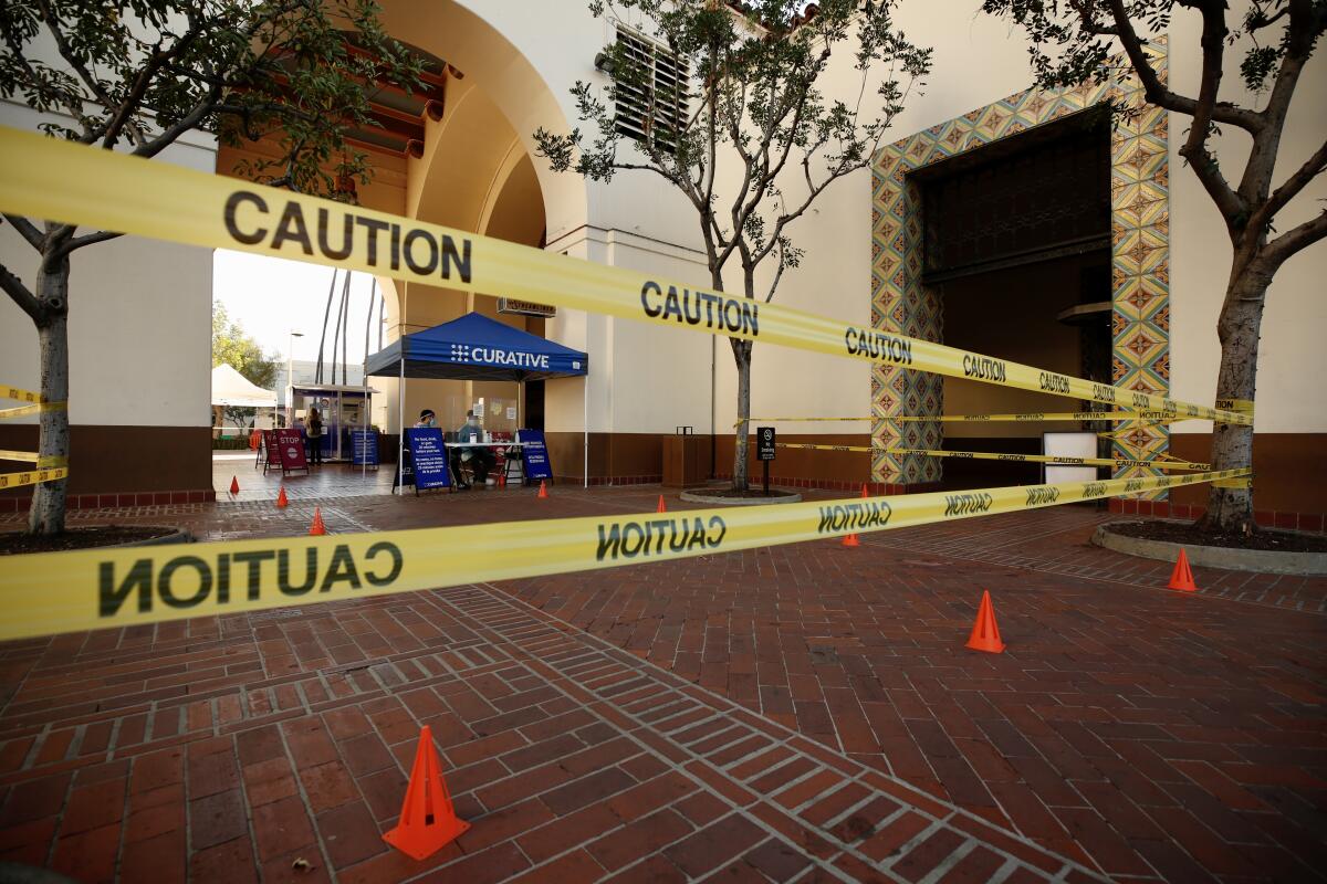 Caution tape in front of a blue tent with the word Curative on it