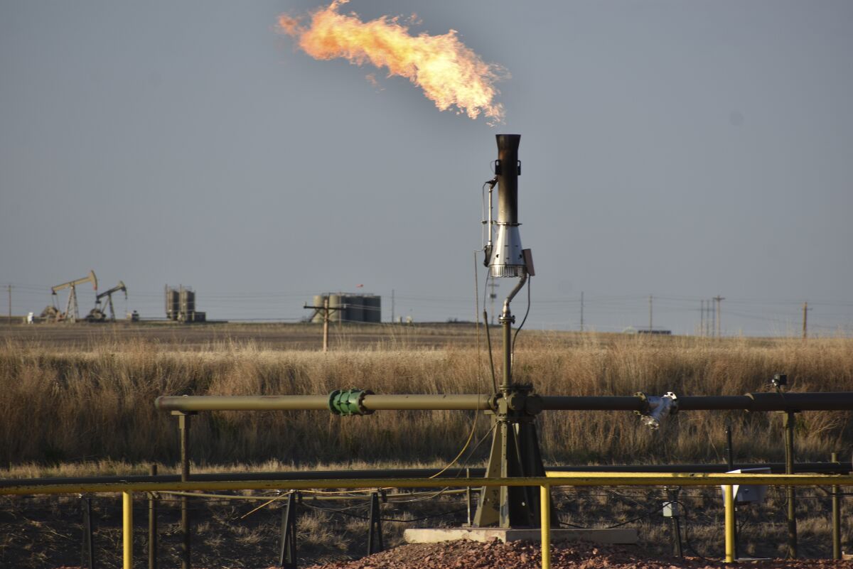 FILE - A flare for burning excess methane, or natural gas, from crude oil production, is seen at a well pad east of New Town, N.D., May 18, 2021. The Interior Department on Monday, Nov. 28, 2022, proposed rules to limit methane leaks from oil and gas drilling on public lands, the latest action by the Biden administration to crack down on emissions of methane, a potent greenhouse gas that contributes significantly to global warming. (AP Photo/Matthew Brown, File)