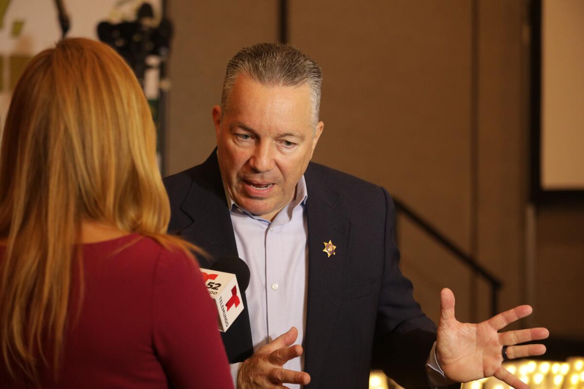 Sheriff Alex Villanueva speaks to a reporter during an election night rally on Tuesday.