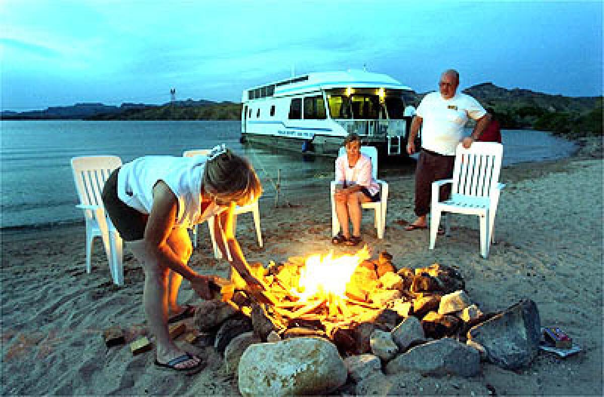 A campfire is the center of attention for Dorothy, left, Ann and Dan in Red Cloud Cove, on Lake Mohaves Nevada shore.