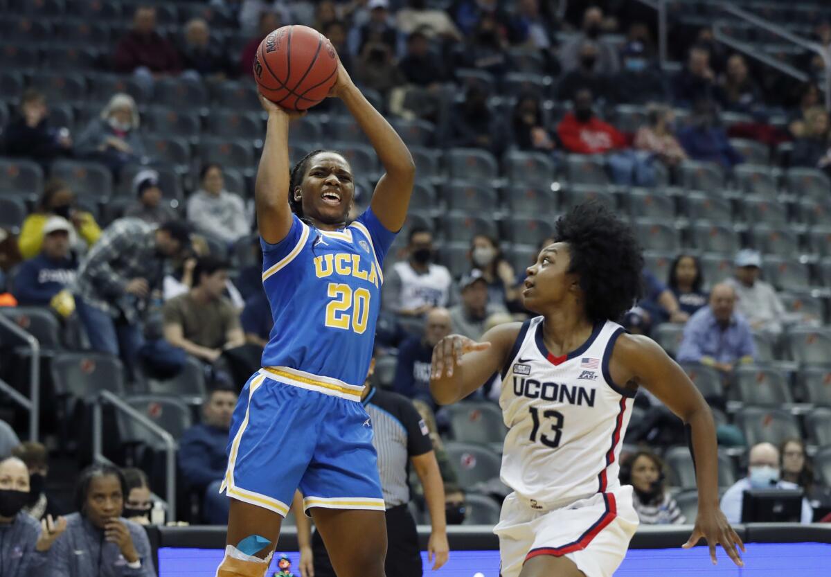 UCLA guard Charisma Osborne shoots over Connecticut guard Christyn Williams.