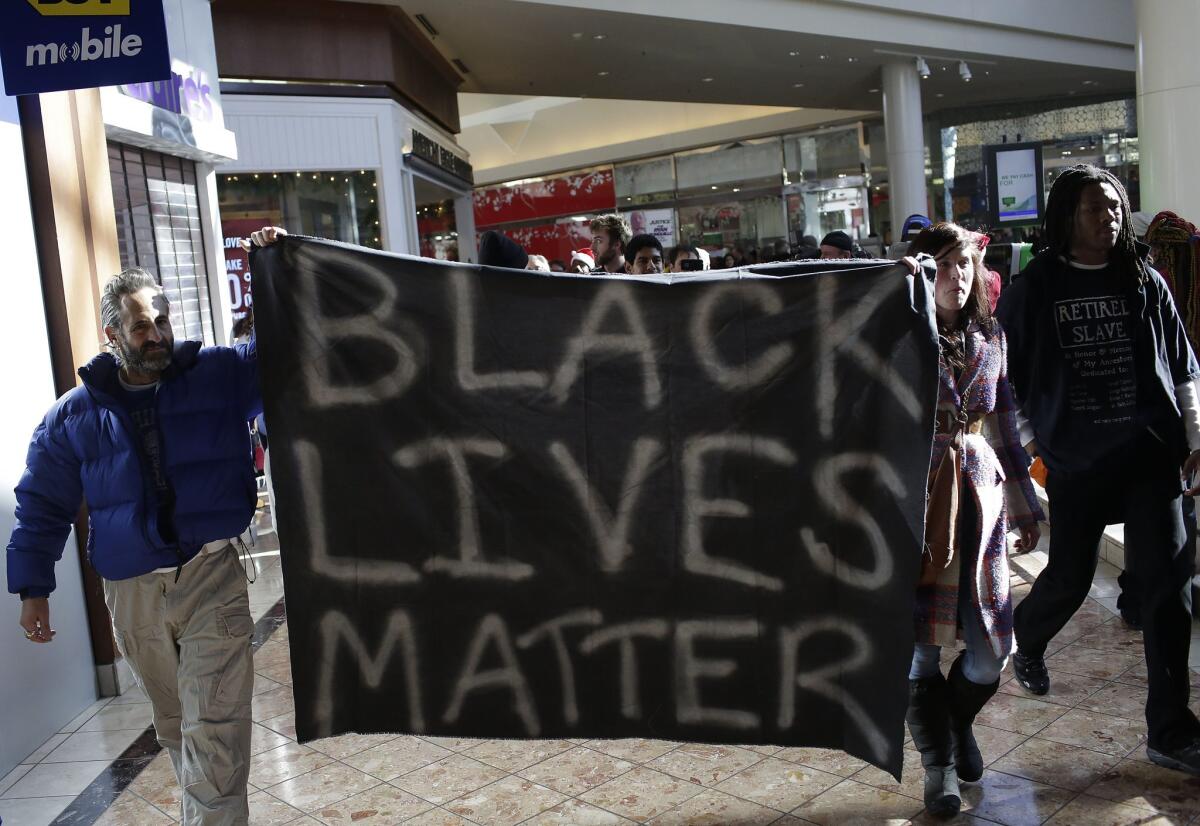 Demonstrators protesting the shooting death of Michael Brown in nearby Ferguson march through the Galleria Mall in St. Louis, yelling slogans to the Black Friday crowd.