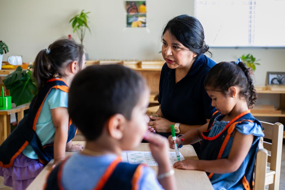 Karla Díaz habla con los niños a los que cuida en su casa de Chula Vista el jueves 20 de julio.