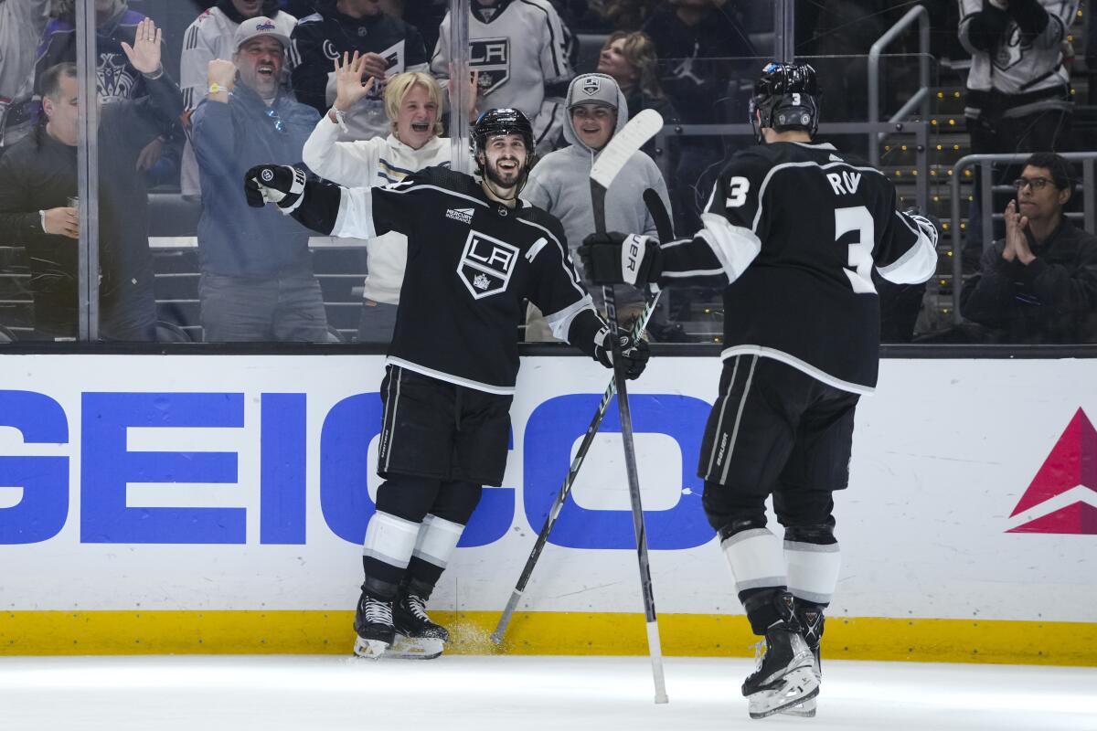 Kings center Phillip Danault celebrates with defenseman Matt Roy against the New Jersey Devils at Crypto.com Arena.