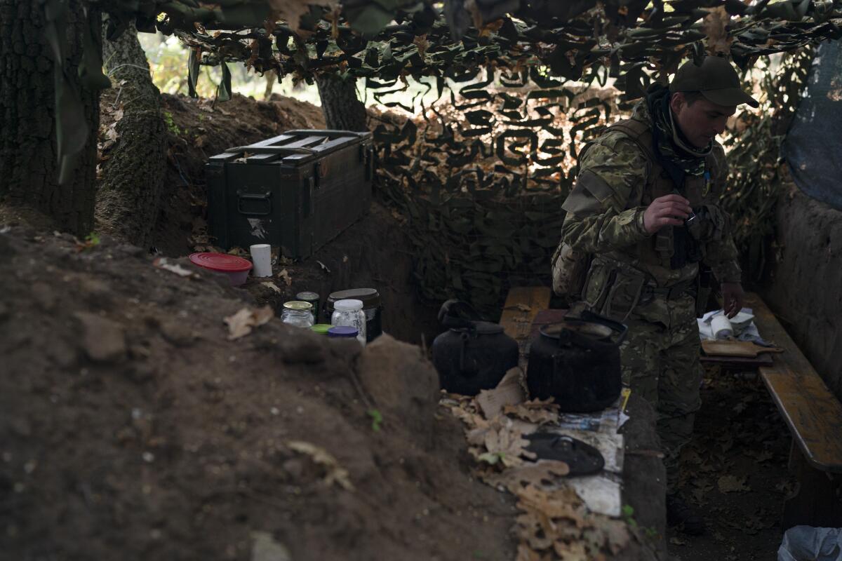 A Ukrainian soldier checking an abandoned Russian trench