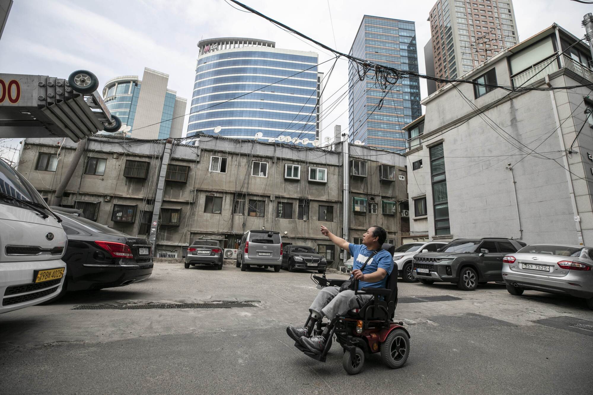 Mr. Yoon Yong-ju points at the windows of the cramped jjokbang houses