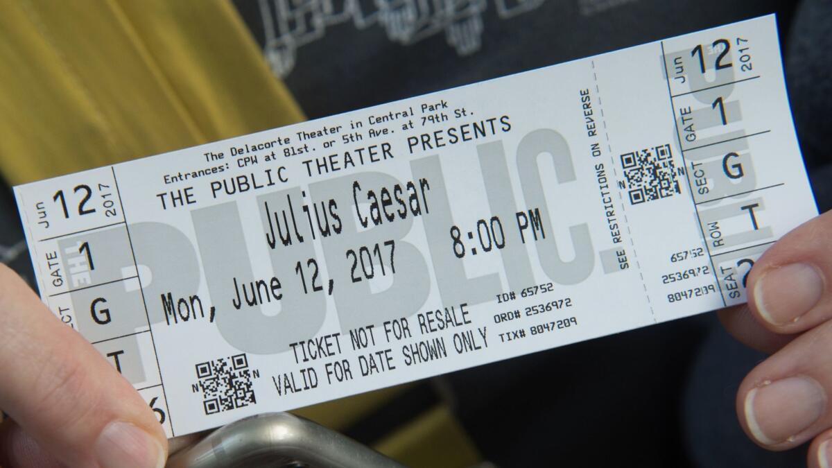 A woman holds her ticket to opening night of Shakespeare in the Park's production of "Julius Caesar" in Central Park.