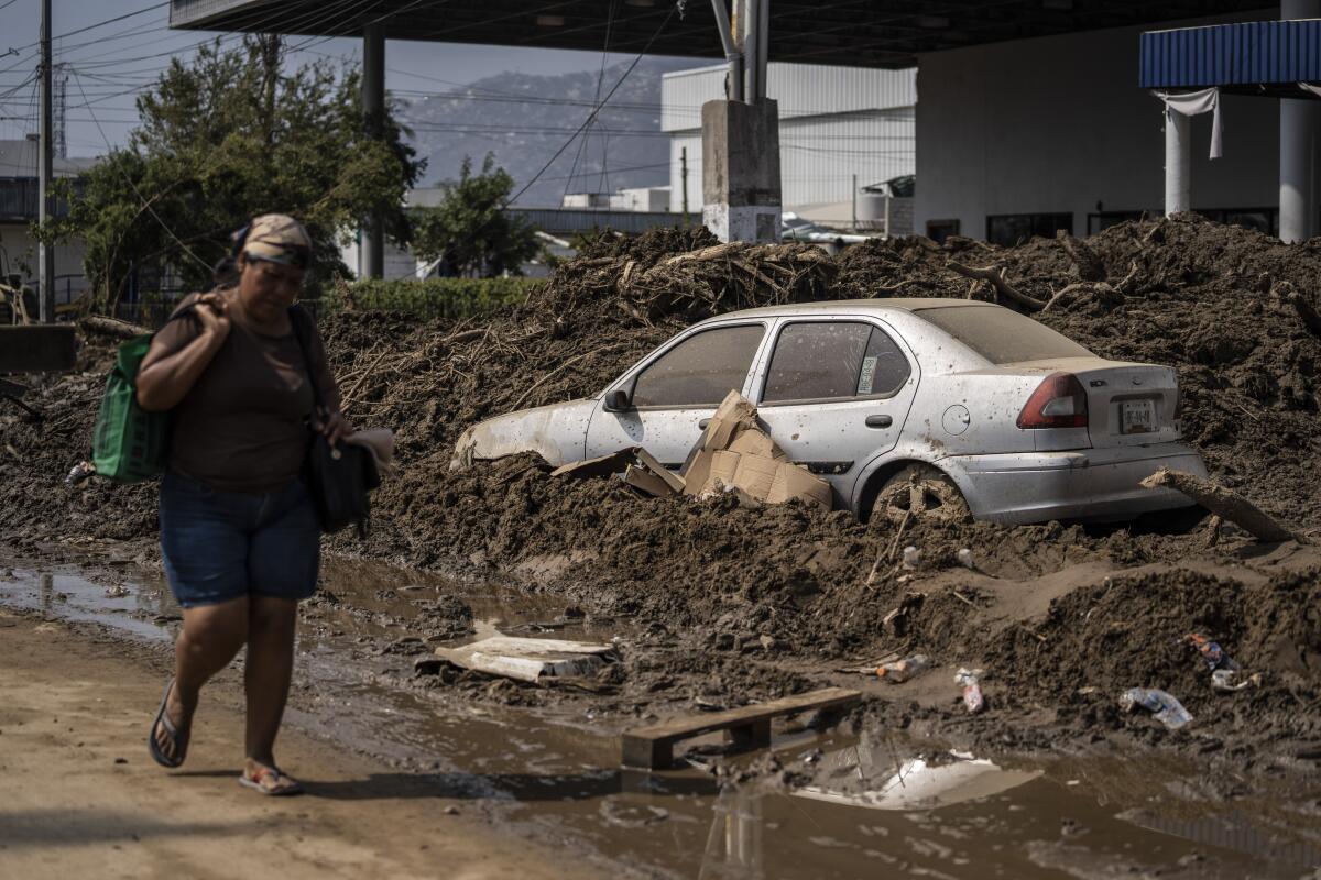 A woman walks through a damaged zone in the aftermath of Hurricane Otis in Acapulco, Mexico