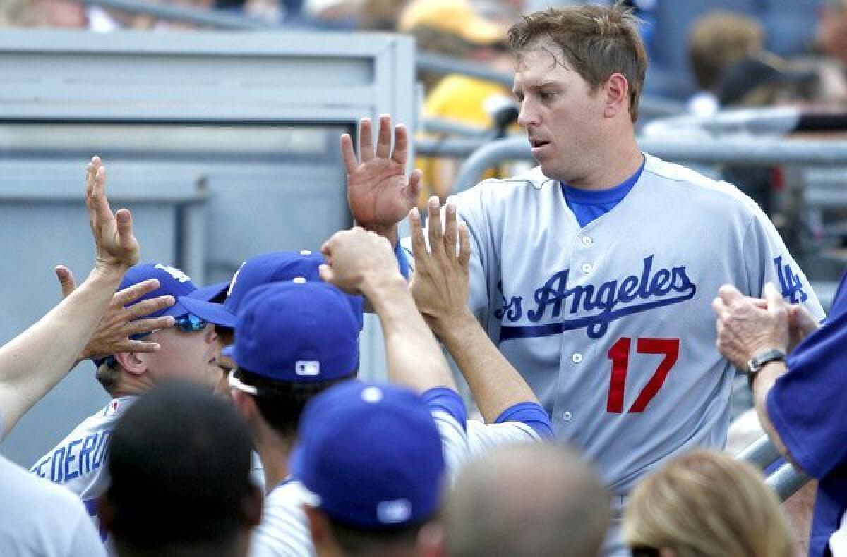 Dodgers catcher A.J. Ellis is congratulated by teammates after scoring against the Pirates in the fifth inning Saturday at PNC Park in Pittsburgh.