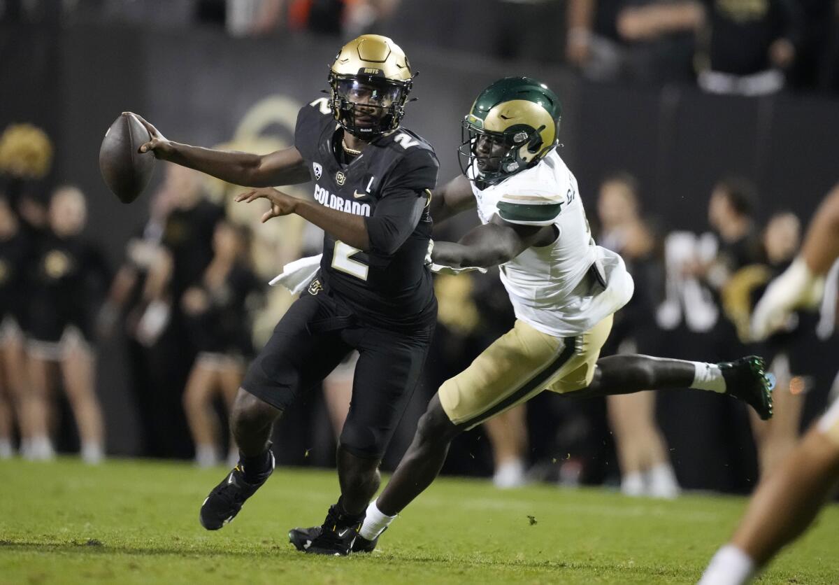 Shedeur Sanders eludes a tackle.