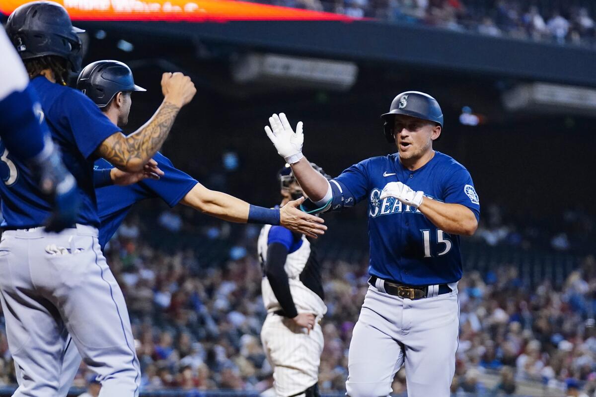 Seattle Mariners' Kyle Seager (15) celebrates his three-run home run against the Arizona Diamondbacks with Mariners' J.P. Crawford, left, and Mitch Haniger during the first inning of a baseball game Saturday, Sept. 4, 2021, in Phoenix. (AP Photo/Ross D. Franklin)