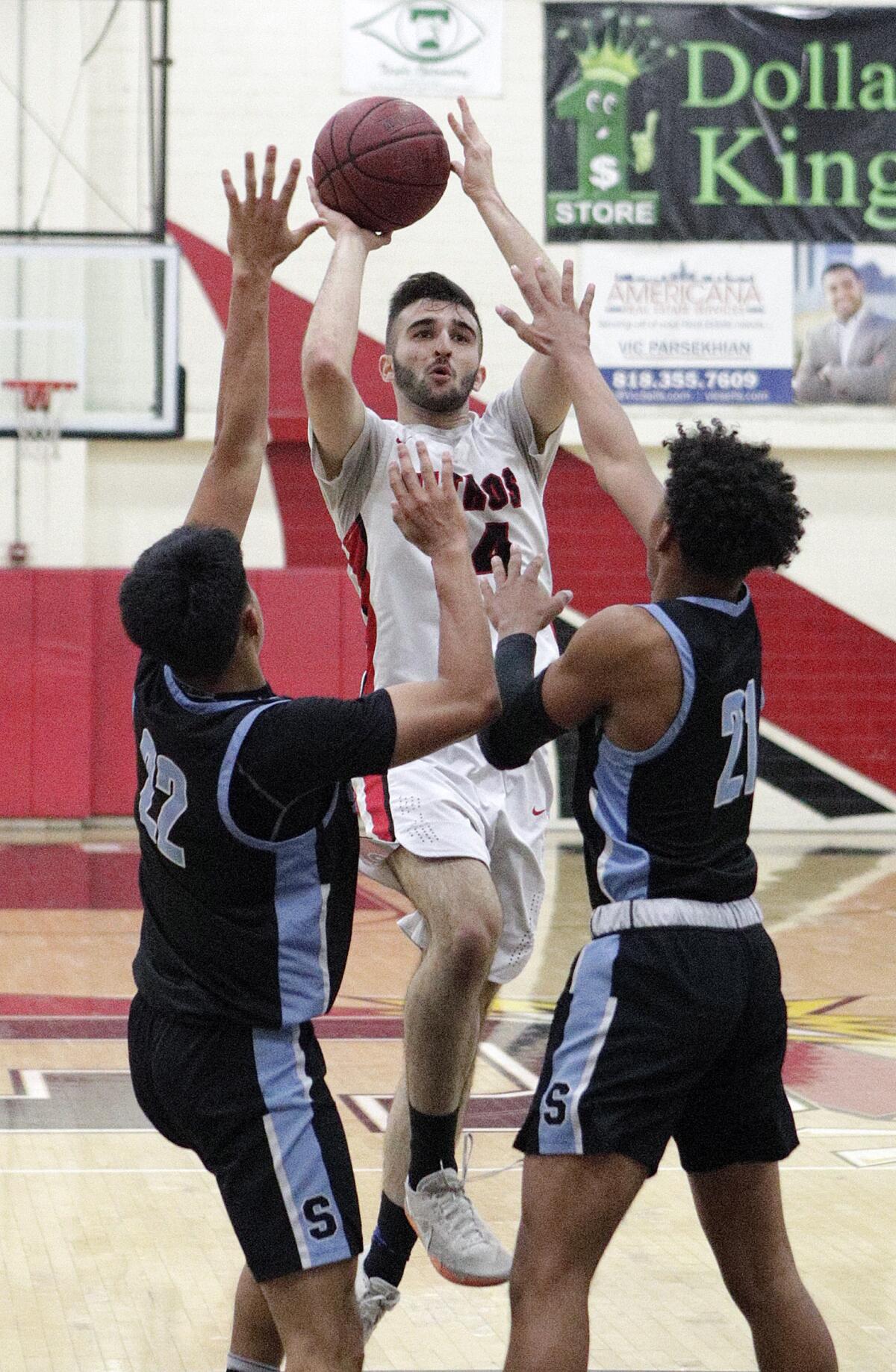 Glendale's David Shamiryan shoots against Salesian's Marc Pallares and Marvin Denson in the CIF Southern Section division III-AAA second-round boys' basketball playoff in at Glendale High School on Friday, February 14, 2020. Salesian won the game in overtime beating Glendale 55-49.