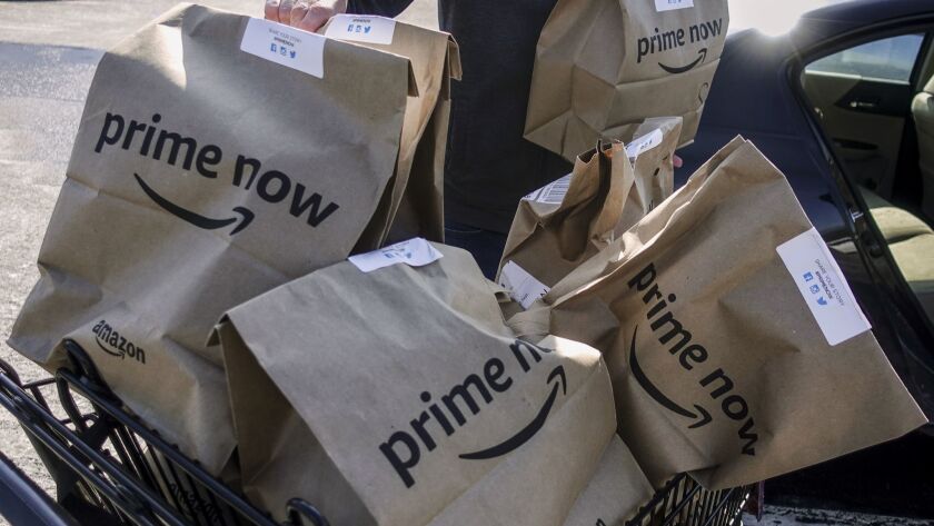 Amazon Prime Now bags full of groceries are loaded for delivery by a part-time worker outside a Whole Foods store in Cincinnati. Amazonâ's Prime Day deals are coming to the aisles of Whole Foods.