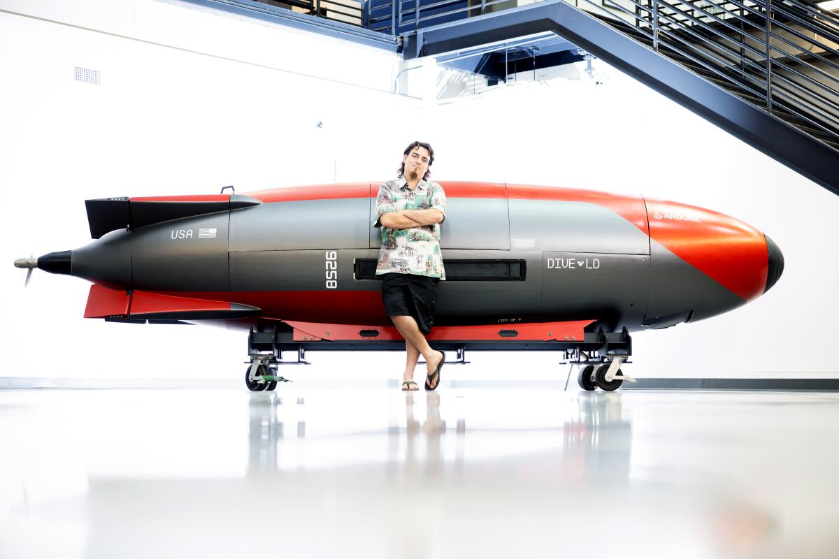 Anduril Industries co-founder Palmer Luckey leans against a large projectile