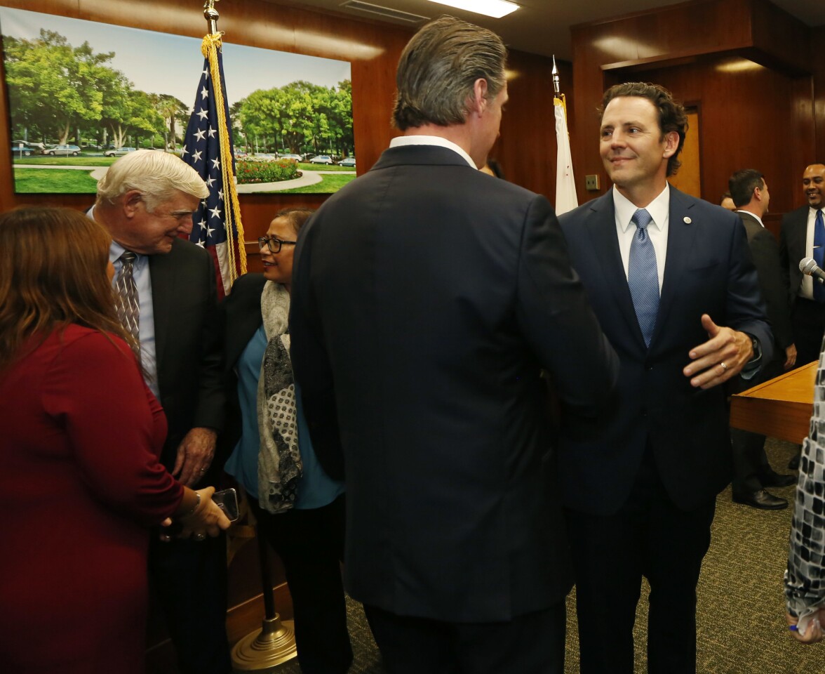 Gov. Gavin Newsom spoke with San Diego leaders about an effort to provide relief and humanitarian aid to asylum seekers in San Diego on Jan. 31, 2019. Newsom's budget proposed $25 million for an immigration rapid response program. Here, Newsom, left, greets County Supervisor Nathan Fletcher. (Photo by K.C. Alfred/San Diego Union-Tribune)