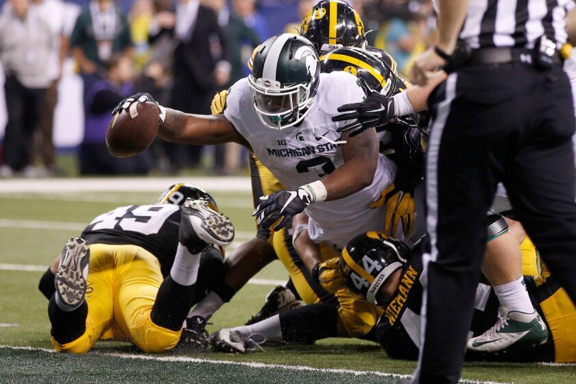 Michigan State running back LJ Scott reaches into the end zone for the winning score against Iowa in the Big Ten Championship.