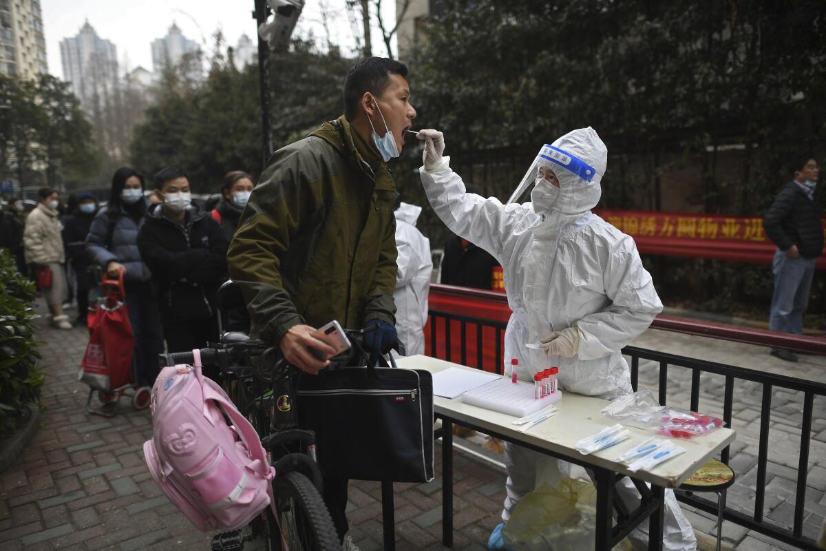 A man gets a throat swab at a residential compound in Wuhan. 