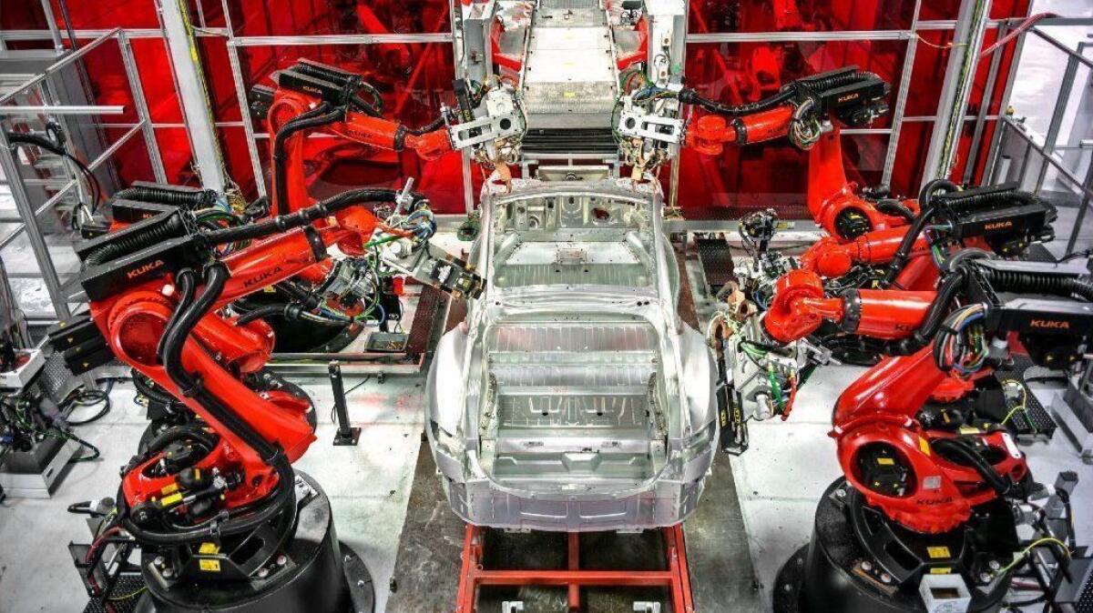 Robots assemble a car at the Tesla factory in Fremont, Calif., in 2015.