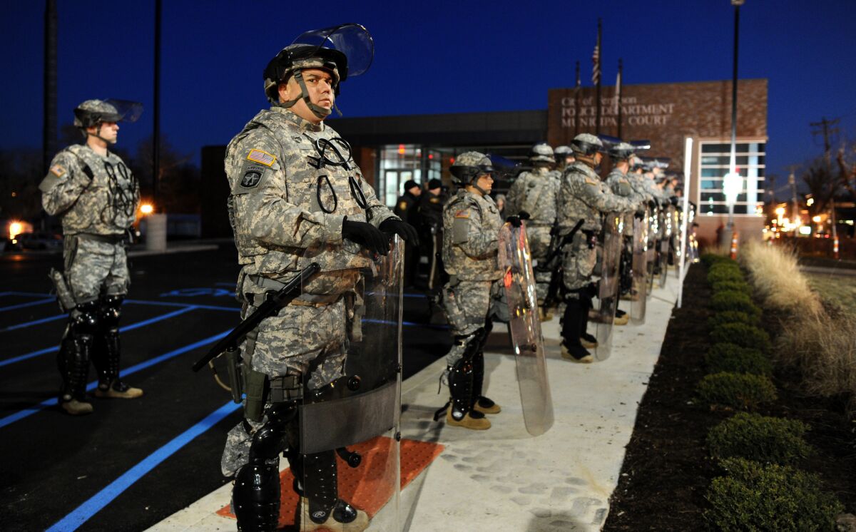 National Guard troops are deployed at the police station in Ferguson, Mo., as night falls on Tuesday.