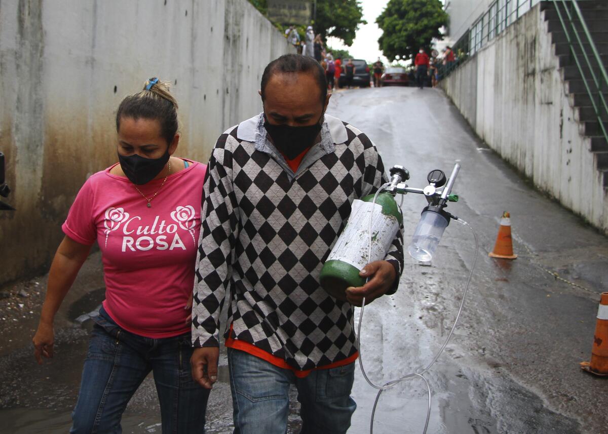 A man carries an oxygen tank that he bought for his mother-in-law, who is hospitalized with COVID-19, in Manaus, Brazil.