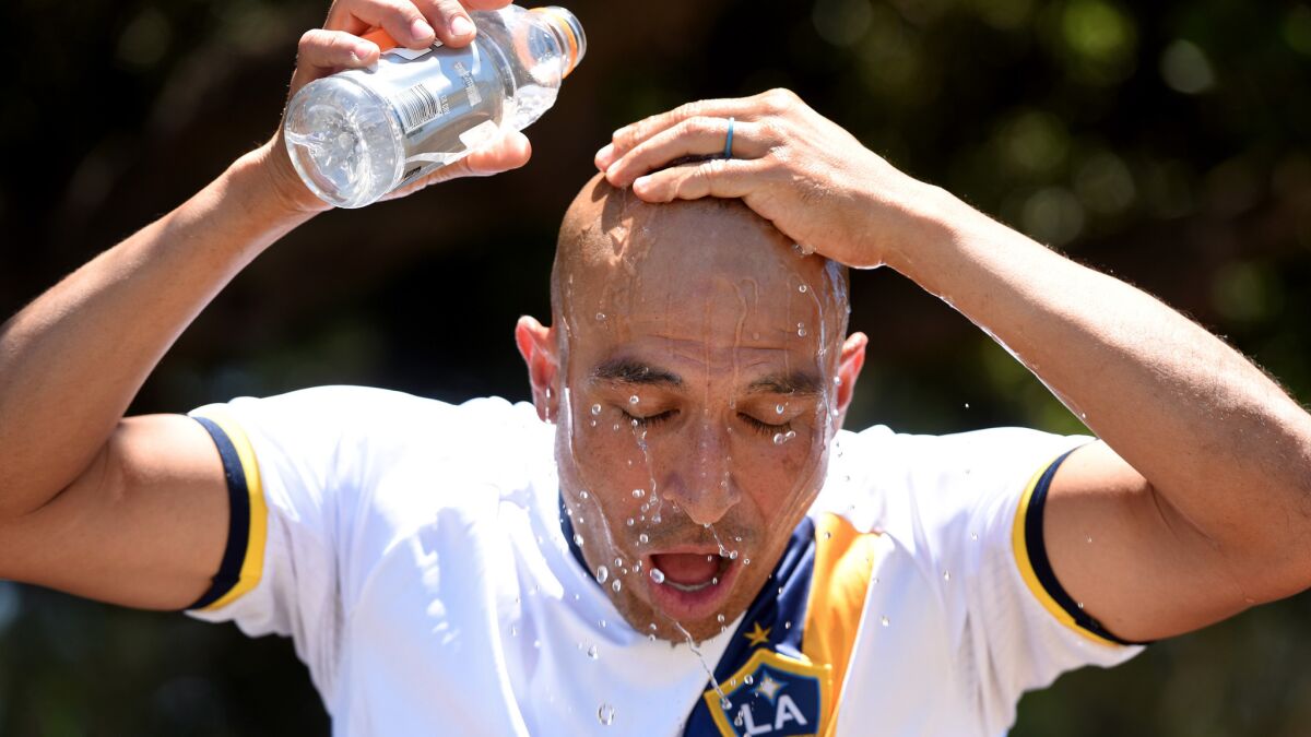 Robert Aguilar pours water on his head during halftime of a soccer game at the Sepulveda Basin Sports Complex.