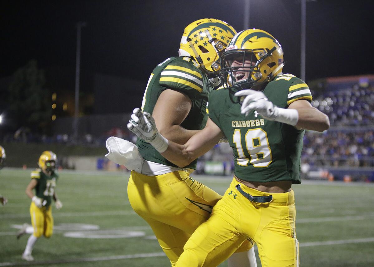 Edison's PJ Campbell (18) and Christian Hazen celebrate a touchdown in a Sunset League game against Fountain Valley at Orange Coast College on Friday.