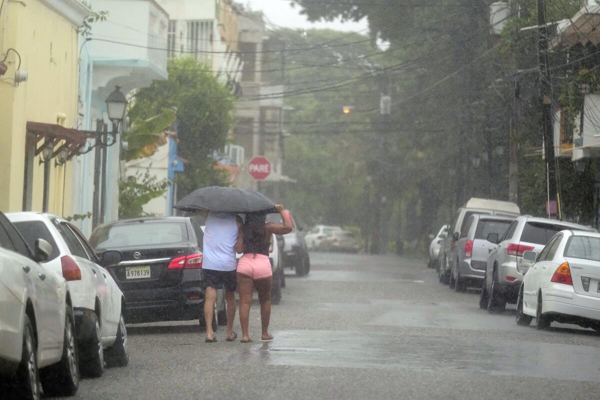 People walking under an umbrella in heavy rain