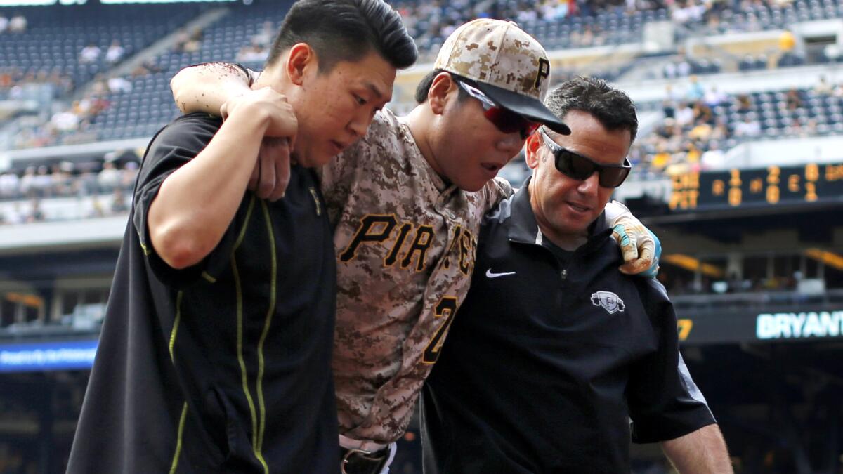 Pirates infielder Jung Ho Kang is helped off the field after injuring his left leg turning a double play in the first inning of a game against the Cubs on Thursday in Pittsburgh.