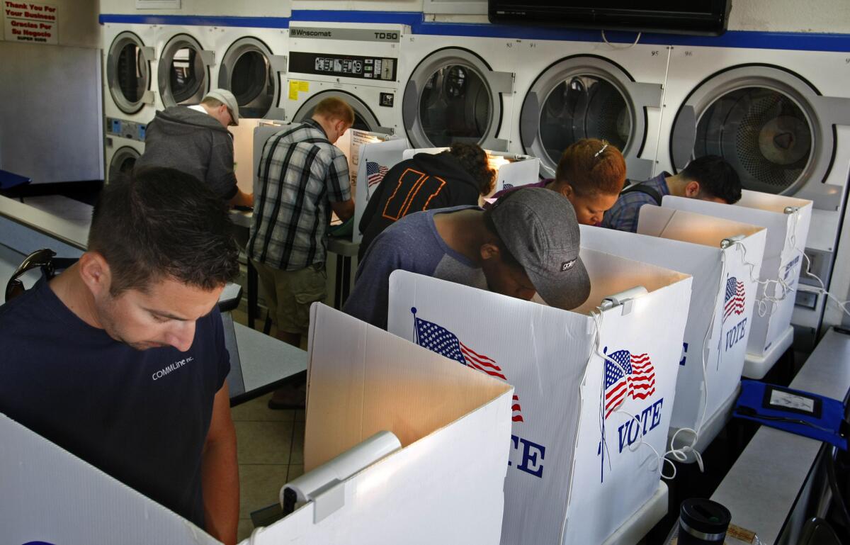 Voters huddle near dryers to mark their ballots at the Super Suds coin laundry in Long Beach, their precinct's polling place on Nov. 6, 2012.