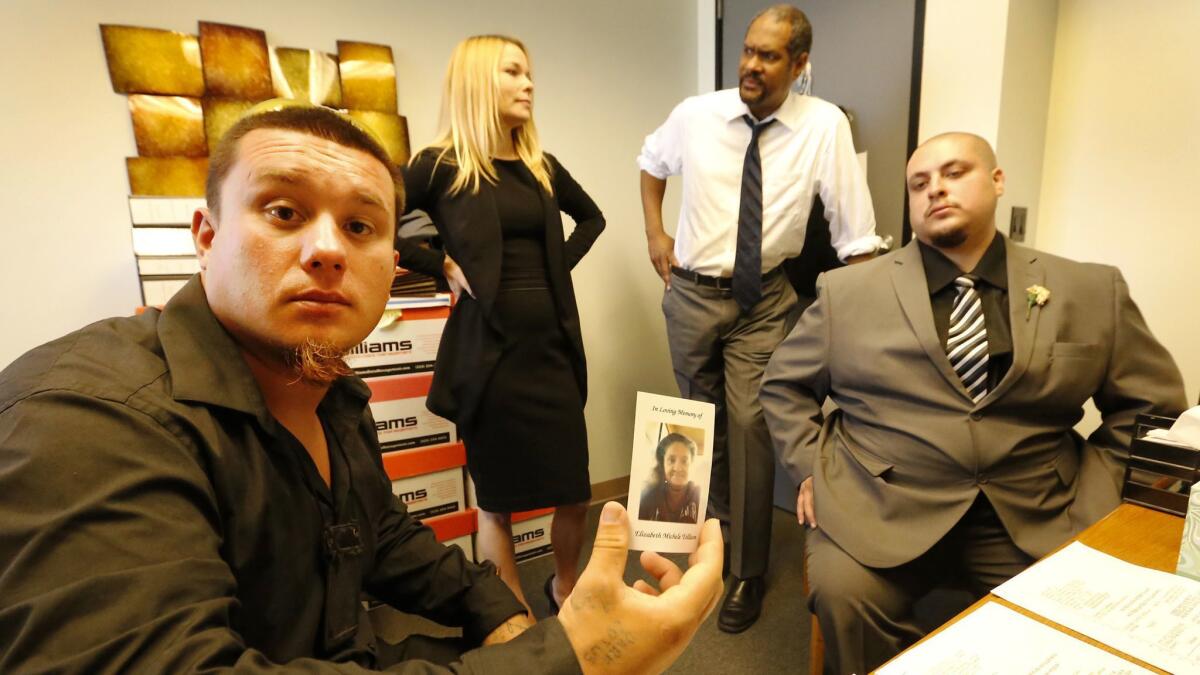 Nick Ramirez, left, and Jesse Pelaez, right, sons of Elizabeth Michele Tollison, who was fatally shot by police during a hostage situation involving a stabbing suspect in Van Nuys, meet with attorneys Megan R. Gyongyos and Brian T. Dunn.