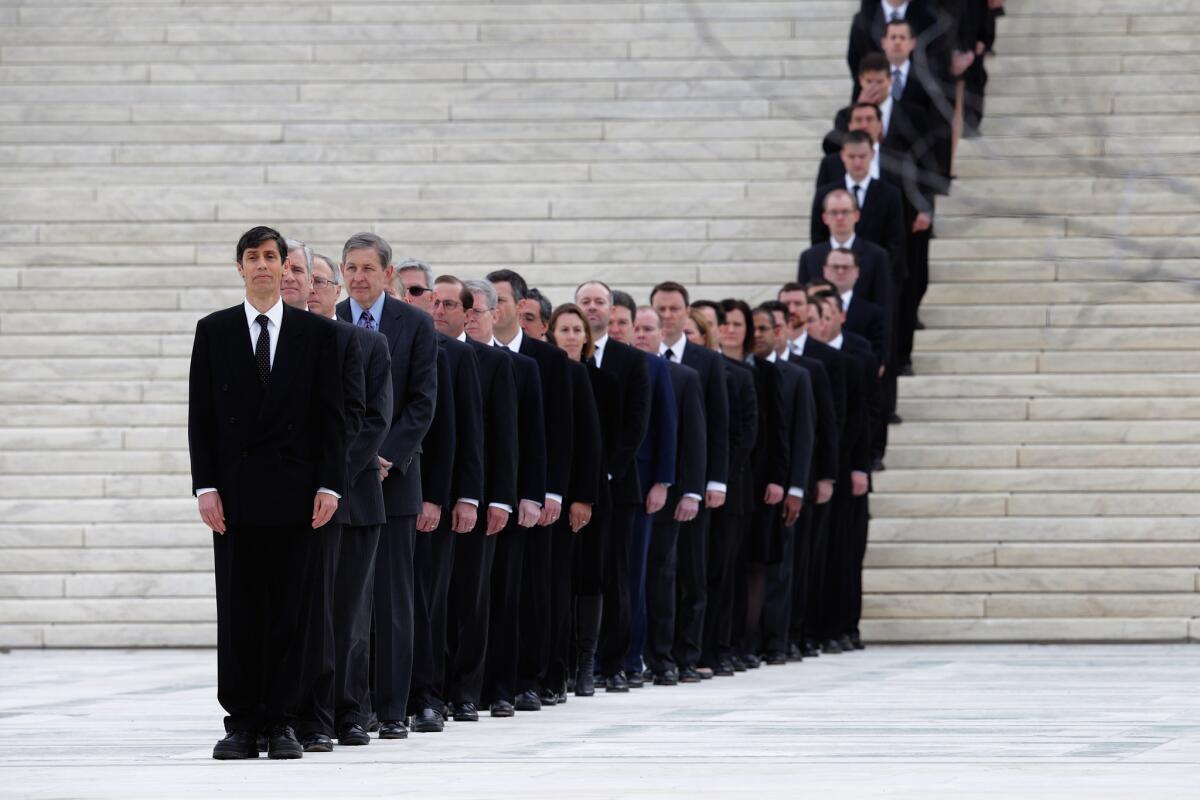 One hundred and eighty law clerks line the stairs in front of the U.S. Supreme Court in anticipation of the arrival of Associate Justice Antonin Scalia's casket at the court building on Friday.