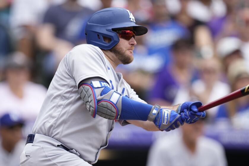 Los Angeles Dodgers' Max Muncy follows the flight of his sacrifice fly to drive in a run off Colorado Rockies.
