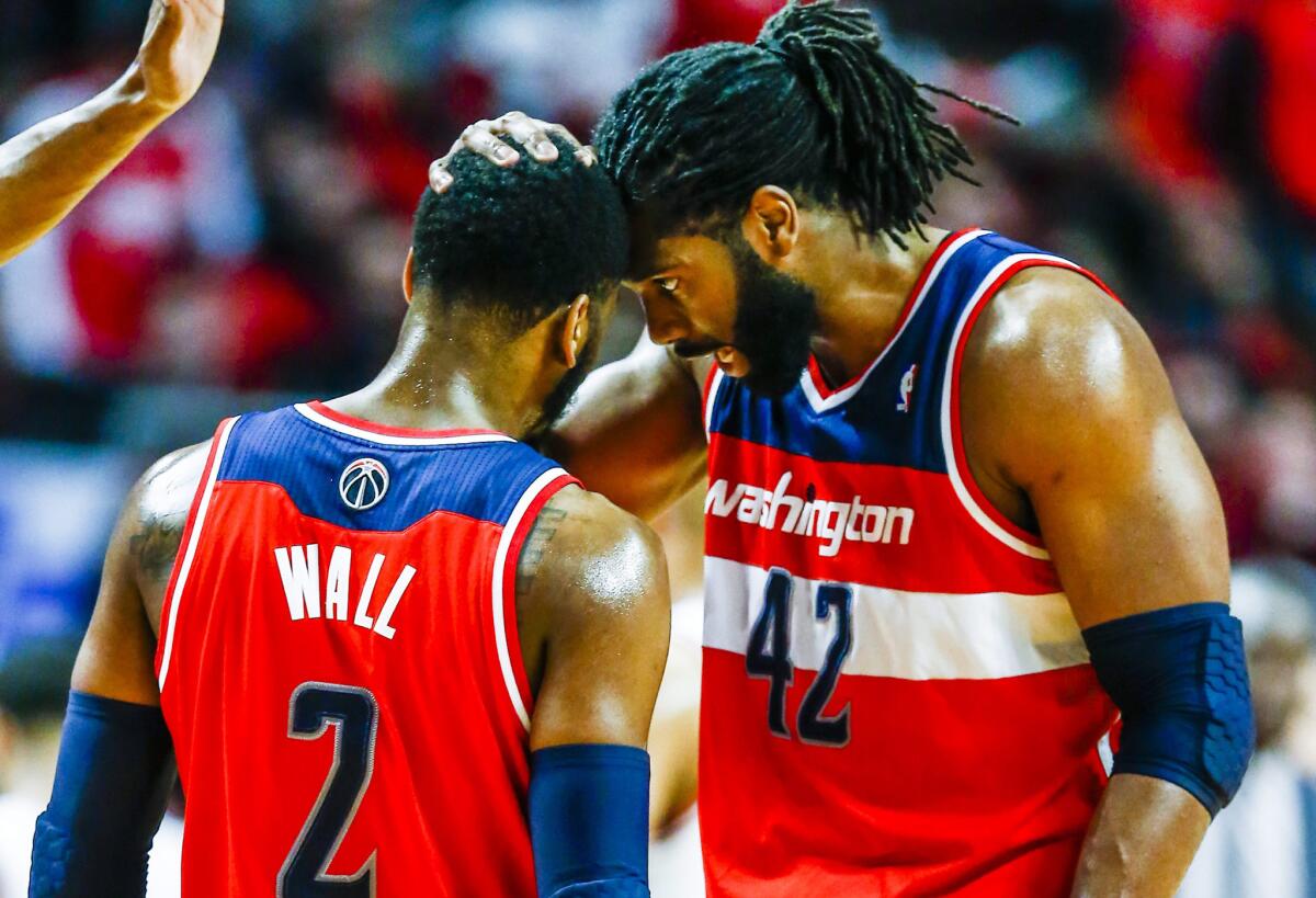 Washington Wizards guard John Wall, left, and teammate Nene Hilario react to a play during the second half of their 101-99 win over the Chicago Bulls on Tuesday.