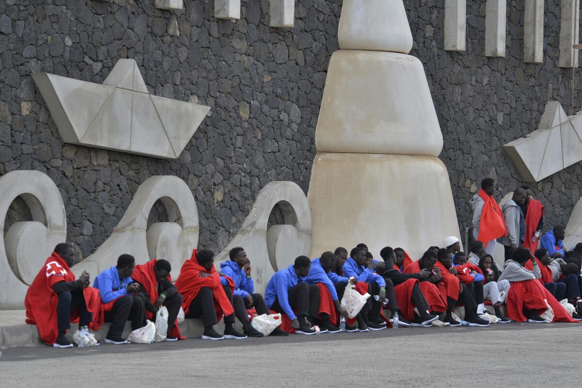 Migrantes sentados en el muelle de La Restinga, en la isla de El Hierro.