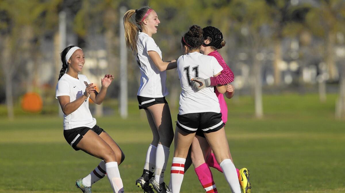 From left, Huntington Beach High’s Brianna Barnes, Alexandra Lotter and Alijah Oliver run to goalie Rachel Harris as the Oilers celebrate after defeating Trabuco Hills 1-1 (3-2 PKs) during an Excalibur tournament match at Irvine Great Park.