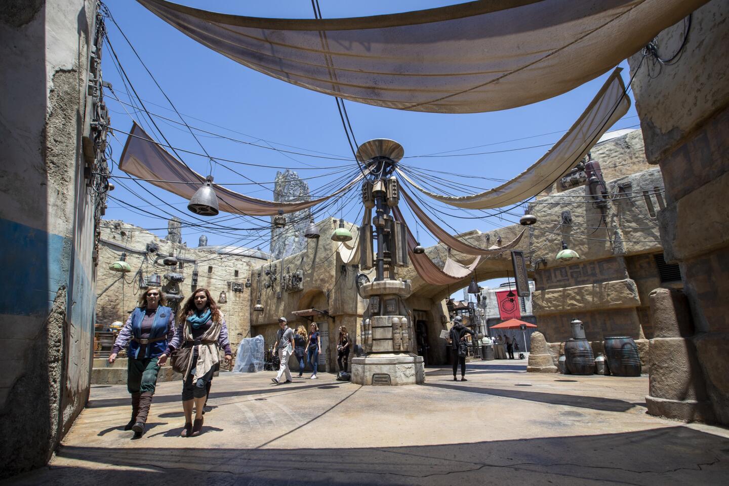 ANAHEIM, CALIF. -- WEDNESDAY, MAY 29, 2019: Cast members walk through the Marketplace as media members get a preview during the Star Wars: Galaxy's Edge Media Preview event at the Disneyland Resort in Anaheim, Calif., on May 29, 2019. (PHOTOS ARE EMBARGOED UNTIL 6PM MAY 29) (Allen J. Schaben / Los Angeles Times)