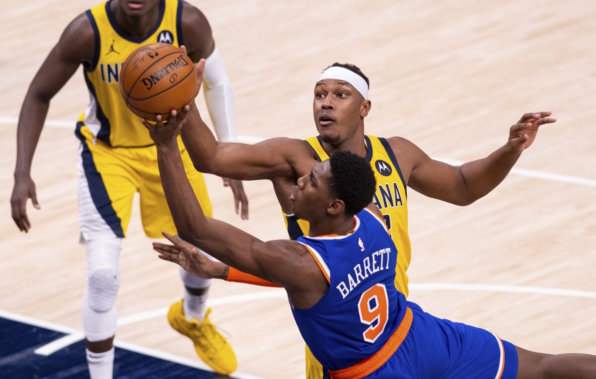 New York Knicks guard RJ Barrett (9) drives a shot to the basket as Indiana Pacers forward Myles Turner (33) tries to block his efforts during the second half of an NBA basketball game in Indianapolis, Saturday, Jan. 2, 2021. (AP Photo/Doug McSchooler)