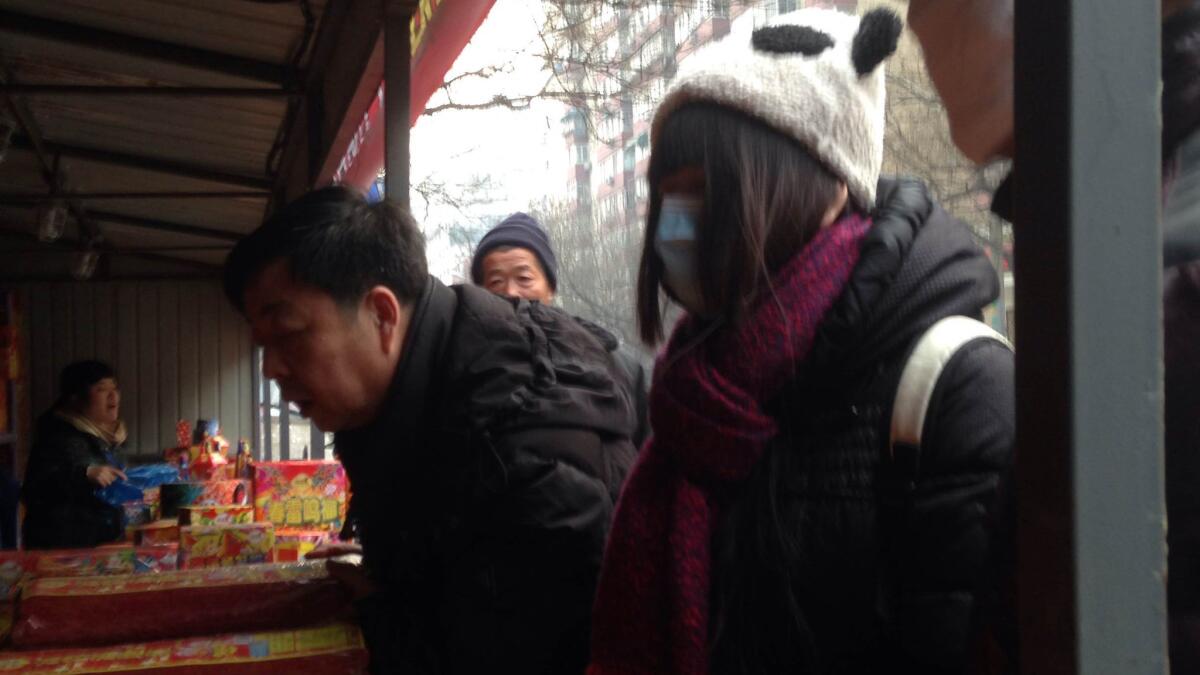 Jia Lin, right, shops at a roadside fireworks stand in central Beijing.