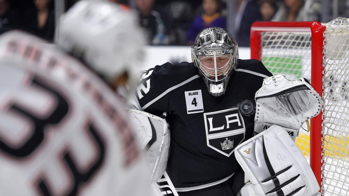Kings goalie Jonathan Quick stops a shot by Ducks forward Jakob Silfverberg, left, during the first period of the Ducks' 3-2 overtime win Saturday at Staples Center.