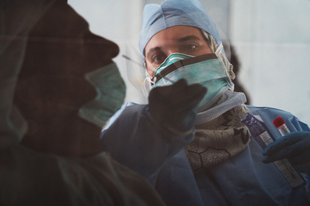 A technician takes a nasal swab for a coronavirus test at a drive-through testing facility in Abu Dhabi.